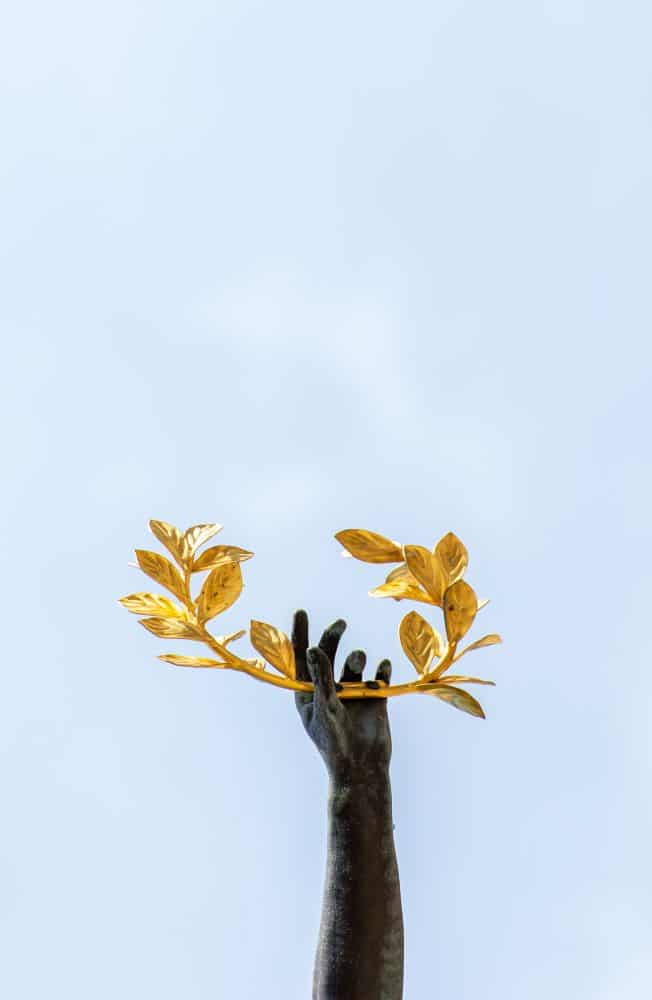 Gold laurel wreath held up by hand