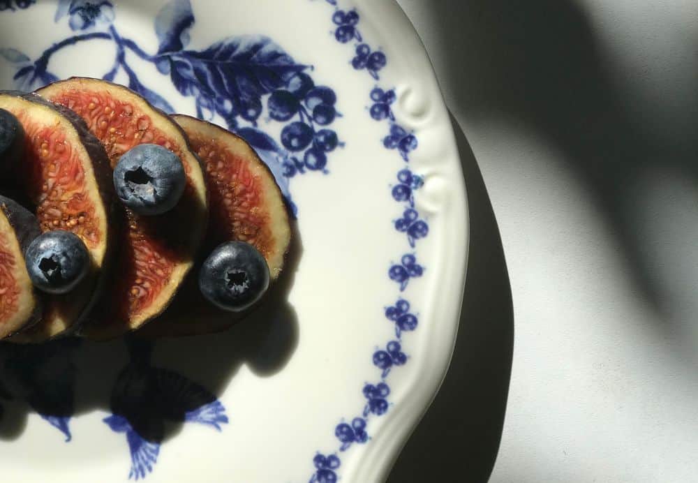 Blue and white plate with fig slices and blueberries
